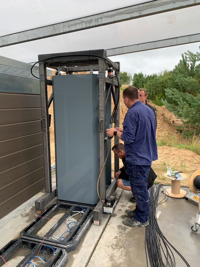 2 workers at Haarup are installing a cabinet.