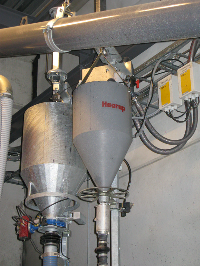 Equipment for liquid colour batching suspended in a bracket and with a safety chain.