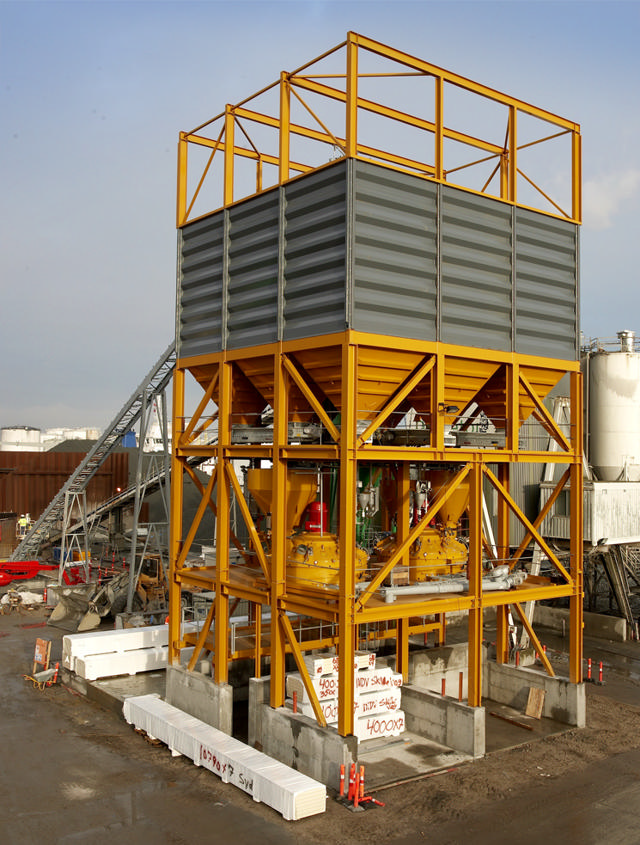 Yellow aggregate bins installed outside with mixers in a solid yellow frame.