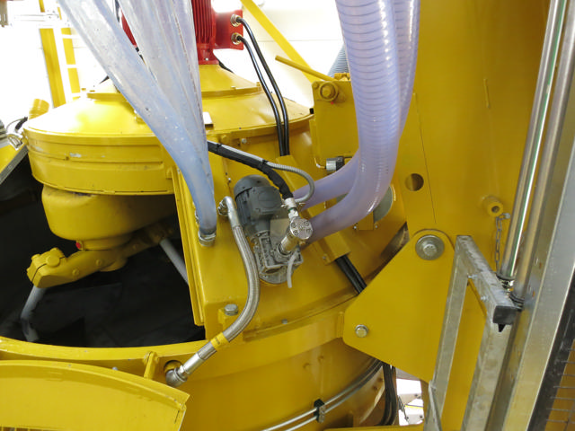 Flushing equipment incl. water hoses fitted on a yellow concrete mixer.